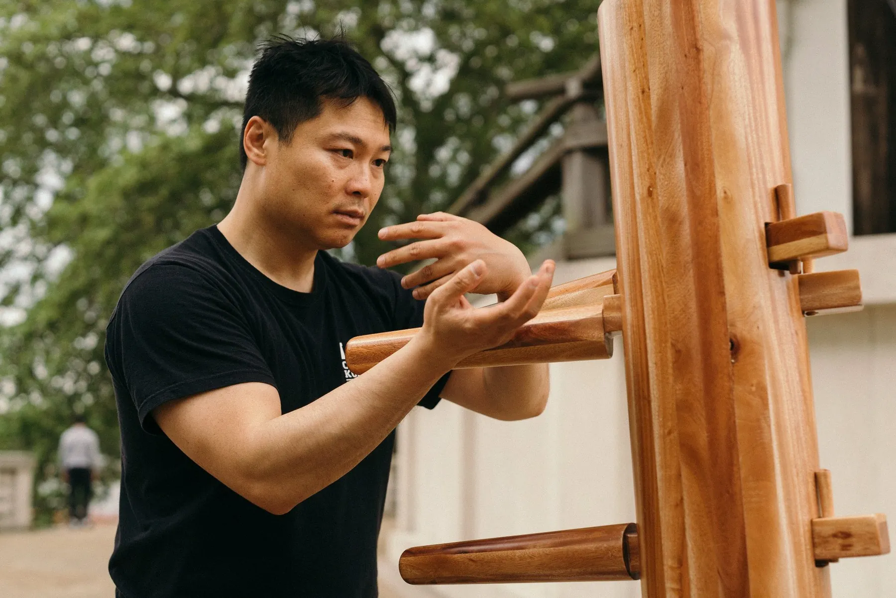 Master Leo Au-Yeung working the wooden dummy outdoors in Battersea Park