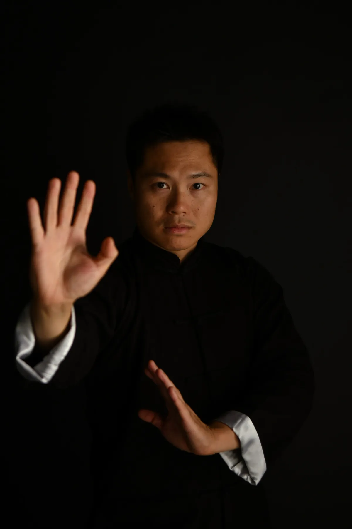 Master Leo Au-Yeung with an open palm raised in a Wing Chun guard